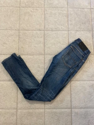 Tiger of sweden jeans  - Snygga blå jeans i modellen Blaise från tiger of sweden med klassisk femficksdesign och raka ben. Jeansen har en mörk tvätt och detaljer i kontrastsömmar. Perfekta till vardagslooken och passar till det mesta. Modellen heter Jade och storleken är 28/32.