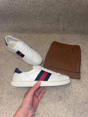 Gucci ace - Hej! Säljer nu mina Gucci Ace sneakers i den klassiska Navy/Red-kombinationen. Storlek 8 (motsvarar ca 42-42.5). Mycket bra skick (8.5/10). Nypris ca 7500 kr, säljs för 2999 kr! OG bruna dustbags medföljer vid köp. En riktigt stilren lyxsneaker som aldrig går ur tiden. Passa på!