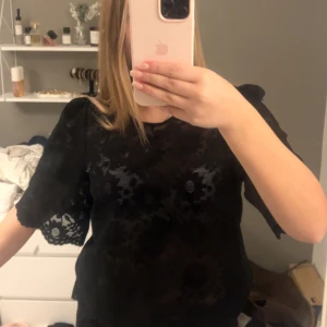 Svart blus i spets med puffärm - Säljer en svart blus i spets med blommigt mönster i Stolek M ifrån bubbleroom❤️