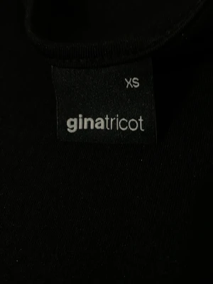 Svart t-shirt från Gina Tricot - En klassisk svart t-shirt från Gina Tricot i storlek XS. T-shirten har rund halsringning och korta ärmar. Tillverkad i mjukt material som känns skönt mot huden. Perfekt basplagg att matcha med allt.