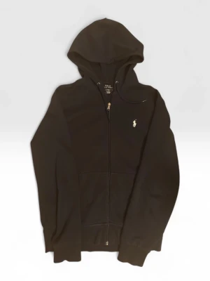 Mörkblå Ralph Lauren Hoodie - Mörkblå  hoodie från Polo Ralph Lauren med klassisk broderad logga på bröstet. Tröjan har huva med snörning, hel dragkedja och två stora fickor framtill. Tillverkad i mjuk bomull och har långärmad passform. Perfekt för chill dagar och streetwear.