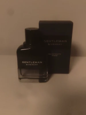 Givenchy Gentleman Eau de Toilette Intense 60ml - Givenchy Gentleman Eau de Toilette Intense är en elegant parfym i en stilren, mörkblå glasflaska med matchande förpackning. Flaskan har en modern, fyrkantig form och tydlig Givenchy-logga på framsidan. Använd max 5 spray, helt ny, passade inte mig tyvärr. 