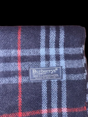 Burberry rutig ullhalsduk mörkgrå - Den klassiska burrberry halsduken i svart, perfekt nu när dey är extra kallt. Ger mycket värme och är extremt skön. 100% cashmere.