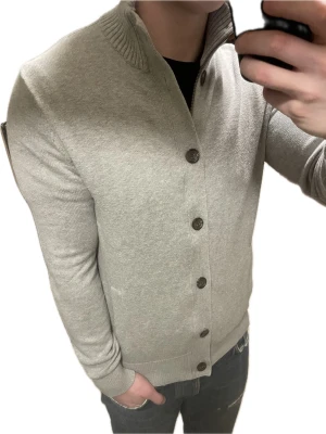 Grå stickad cardigan - Otroligt snygg grå stickad cardigan. Passar perfekt till kallare väder. Modellen är 180cm, 75kg. Priset kan såklart diskuteras