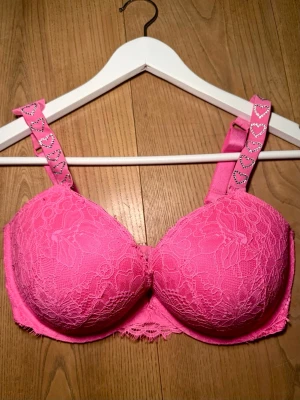 Victorias Secret bh - Jättesöt rosa victorias secret push up bh med rhinestone hjärtan 🩷 Perfekt till alla hjärtans dag!  Lappen är bortklippt men den är i storlek 70E/32DD Tyget är lite löst på ena sidan (se bild), men det påverkar inte användningen! Skriv privat för fler bilder/frågor 🫶🏽