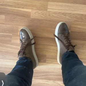 Lanvin skor - Snygga bruna sneakers med mocka på sidorna och glansig, lackad tå i mörkbrunt. Storlek uk 10 tvär feta, bara höra av dig vid frågor. Dunder skick. Pris kan diskuteras/byten är intressanta/Alex🫡