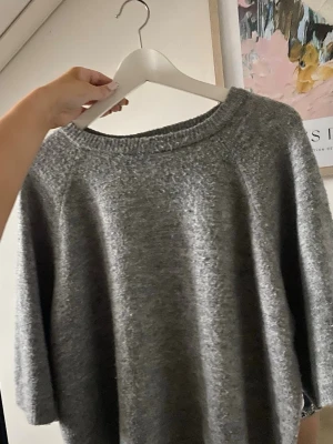 Grå stickad tröja med kort ärm - Mysig grå stickad tröja från 157 i storlek (M)men kan variera från person till person. Perfekt att ha hemma eller på skolan/jobbet. Köpte tröjan för ungefär 1,5 år sen, men har ändå inte någon skada. Har använts fåtal gånger.  Skriv gärna frågor om ni undrar något!❣️