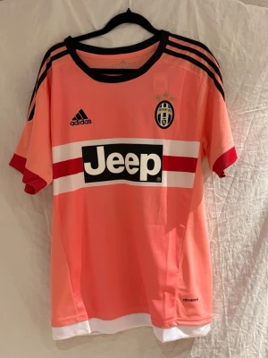 Juventus Dybala 21 - Säljer en rosa Juventus tröja fråm 15/16 säsongen. Bakom ryggen så gömmer sig Dybala nummer 21. Tröjan har svarta ränder på axlarna och är tillverkad i lätt, ventilerande climacool-material.