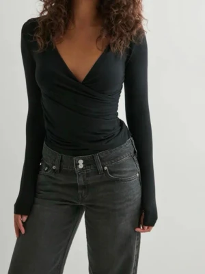 Svart omlottopp med v-ringning - Jättefin svart tröja från Nelly, passar till precis allt och har ett väldigt mjukt material❣️