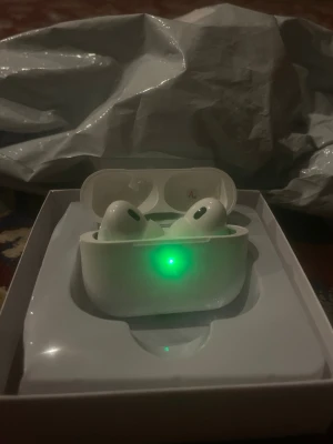 Vita trådlösa hörlurar TWT - Säljer ett par vita Apple AirPods Pro med laddningsetui. Hörlurarna har en stilren och kompakt design med silikonproppar och laddas i det medföljande etuiet. Perfekta för musik, samtal och gaming. Levereras i originalförpackning.