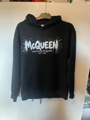  hoodie från Alexander McQueen - Snygg svart hoodie från Alexander McQueen.  Hoodien har huva. Perfekt för dig som gillar streetwear och vill sticka ut med ett ikoniskt plagg. Står storlek L men skulle säga att den sitter som en M i storlek. Om ni har några frågor eller funderingar så är de bara att höra av sig!😊