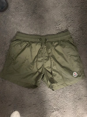 Moncler badbyxor  - Endast använda 1 gång. Mörkgrön. Storlek M/S.passar om du är 165-175. Hör av dig vid minsta lilla fundering! 