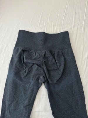 Mörkgrå/blå tränings tights  - Säljer ett par mörkgrå/blå tränings tights med hög midja och scrunch-detalj bak. Materialet är stretchigt och mjukt, perfekt för träning eller chill. Inga synliga loggor eller märken. Passformen är tight och följsam. Köpta ifrån Shein i storlek M. Använt få tal gånger. 