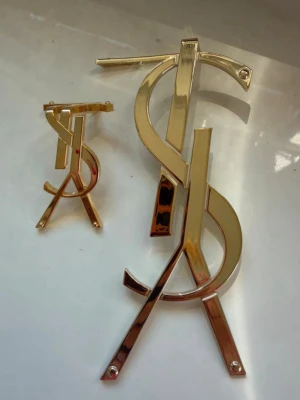 Decor ysl  - Två stycken decor utsmyckning till alla typ av lådor eller väska. Kan Limas på