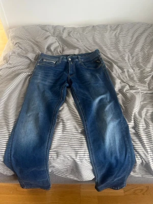 Blå jeans från Replay - Pris kan diskuteras. W28 men passar 29 och 30, L30 Säljer ett par klassiska blå jeans från Replay med raka ben och fem fickor. Jeansen har snygga slitningar framtill och kontrastsömmar på bakfickorna. Tillverkade i denim med en cool tvättad look. Perfekta till en avslappnad stil.