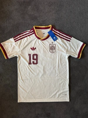 Spanien VM 26/27 borta Lamine Yamal 19 - Fotbollströja med Lamine Yamal på ryggen. Tröjan är helt ny med tagg kvar och i perfekt skick. Perfekt för dig som är supporter, samlar på fotbollströjor eller vill ha en snygg tröja till träning och vardag.                                                                      ⚪ Skickas inom 24 timmar.                                         Vid intresse eller frågor är det bara att skicka 👍