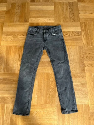 Grå jeans från Nudie Jeans - Säljer ett par grå jeans från Nudie Jeans. Jätte bra skick med inga hål eller något sånt. W33 L32.Perfekta till en avslappnade stil.