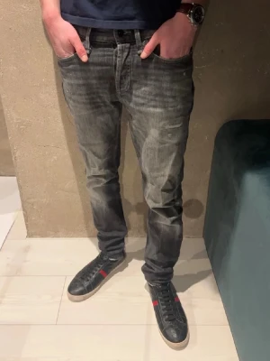 Jeans - Jeans från Denham. Modellen är 185cm. Grå svart färg.