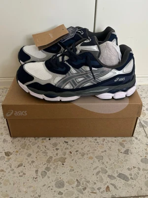 ASICS vita och marinblå sneakers - Unika och feta Asics i storlek 42. Box medföljer såklart och originaltags. Passar perfekt till sommaren och kan användas till allt egentligen.