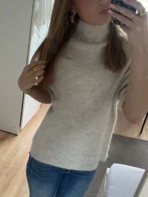 Stickad tröja  - Säljer en beige stickad polotröja med korta ärmar och hög krage. Är ifrån Gina Tricot i storlek xs❤️