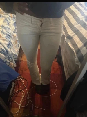 Vita bootcut jeans  - Säljer ett par vita bootcut jeans  med klassisk femficksmodell och dragkedja med knapp. Jeansen har en snygg passform som sitter tight upptill och släpper vid vaden. Perfekta till en trendig vardagslook. Korta på mig som är 171, skulle passa 165 neråt!💓