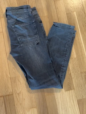 Gråa Jack & Jones jeans - Säljer ett par fräscha Jack & Jones jeans i färgen grå. De är i super bra skick och inte mycket använda. Skriv angående frågor eller pris.