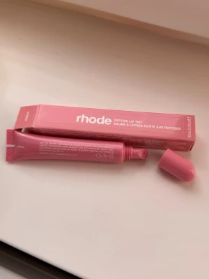 Rhode Peptide Lip Tint ribbon - Rhode Peptide Lip Tint läppbalsam (ribbon). Självklart helt oanvänd, fick med i goodiebag men inget jag kommer ha användning av 🌸