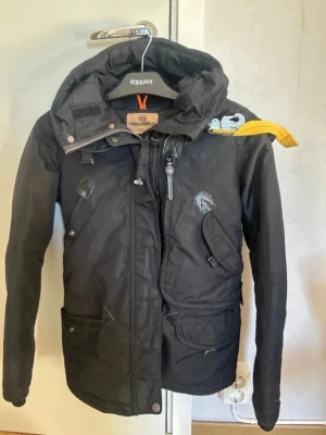 Svart parkas från Parajumpers - Snygg svart parkasjacka från Parajumpers med huva, flera praktiska fickor och kommer även med päls luva, så är du intresserad skriv till mig så clonar jag bild med pälsen på.