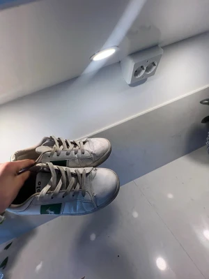 Vita Polo Ralph Lauren sneakers - Snygga vita sneakers från Polo Ralph Lauren med gröna detaljer och klassisk logga på sidan. Skorna har lågt skaft, vita snören och är tillverkade i läder med textilfoder. Perfekta för en stilren och sportig look.