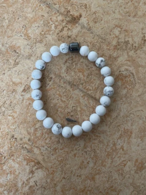 All cap 1 armband  - Snyggt armband men svarta är trasigt saknar 3 kulor fast går att bygga ihop igen ingen skada på pärlorna bara snöret som har spräckt annars i jättebra skick 