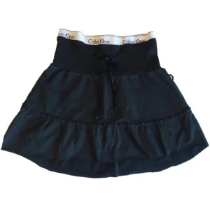 Volangkjol/ tygkjol/ minikjol/ miniskirt/ midikjol, Calvin Klein, y2k/ cyber/ alt/ coquette/ velour/ ribbad/ 2000tal/ 00tal - Supercool unik mini tygkjol med påsydd Calvin Klein resår & med velourband! (Obs! Man får sätta på sig den försiktigt då sömmen kan gå upp om det stretchas ut för mycket) kjolen är avklippt längst ner, går att klippa kortare om man vill ha den ännu mer ”mini”