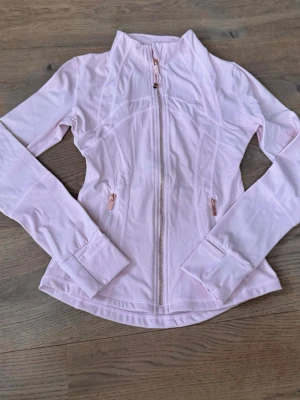 Lululemon define jacket ljus rosa  - Säljer en oanvänd lululemon define jacket  i storlek S. Tröjan är endast testad och i samband med det klipptes tvätt lappen inuti av pga lång och störande. Först till kvarn 🌸