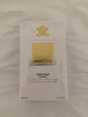 Creed Millésime Impérial 100 ml - Lyxig parfym från Creed, Millésime Impérial, i en elegant vit kartong med guldfärgad detalj och logotyp. Förpackningen är stilren och exklusiv, perfekt för dig som vill ha en klassisk och tidlös doft.