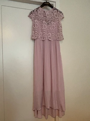 Långklänning med spets - Långklänning med vacker spets upptill och korta ärmar. Klänningen är i två delar. 