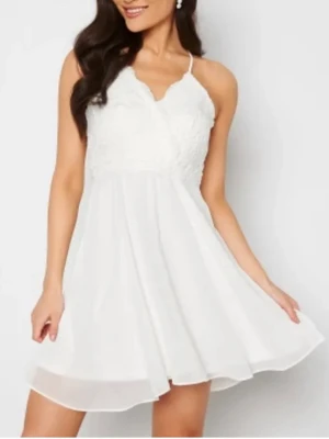 Chiara Forthi vit klänning  - Söt vit kortklänning med smala axelband och omlottdesign upptill. Överdelen har fina spetsdetaljer och kjolen är i ett lätt material. Storlek: 34