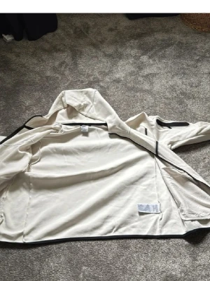 Beige hoodie från Nike XL - Säljer en beige hoodie från Nike i storlek XL. Hoodien har en klassisk huva och är tillverkad i mjukt material som känns skönt mot huden. Perfekt för dig som gillar en clean och enkel stil med sportig touch.
