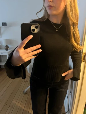 Svart stickad tröja med vida ärmar - Mjuk och skön tröja med slit vid handlederna 