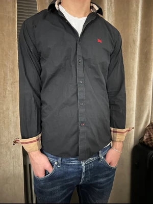 Svart Burberry skjorta  - Hej! Säljer en svart Burberry skjorta från Farfetch. Storlek S/ modellen är 1.80. Haft den i ett tag men är i fint skick( inga defekter) kvitto tillkommer/ DMa💥