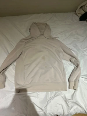 Beige hoodie från H&M - Snygg beige hoodie från Les Artisans med trycket 'LES ARTISANS du bon espoir' på bröstet. Hoodien har en klassisk huva med dragsko och en stor magficka. Tillverkad i mjukt bomullsmaterial och har ribbade muddar vid ärmar och nederkant. Har ett fettstänk i mitten på bröstet.