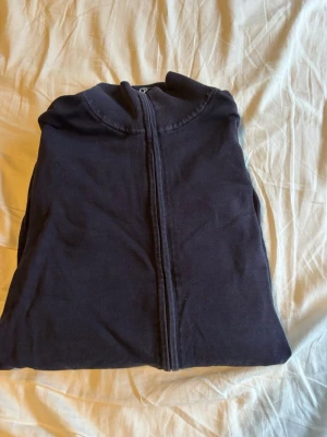 Mörkblå hoodie från John Henric - Snygg mörkblå hoodie från John Henric med dragkedja framtill och klassisk huva. Tillverkad i mjukt bomullsmaterial som känns skönt mot huden. Perfekt för en avslappnad och stilren look.  True to size 