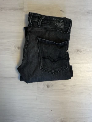 Replay jeans - Snygga svarta jeans från Replay med klassisk femficksdesign och diskret logga på bakfickan. Jeansen har raka ben och är tillverkade i ett mjukt denimtyg som ger en avslappnad men stilren look. Storlek 30/30 anbass slimfit
