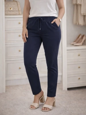 Mörkblå mjukisbyxor med dragsko - Snygga mörkblå mjukisbyxor med smal passform och elastisk midja med dragsko. Byxorna har sidofickor och är tillverkade i ett mjukt, stretchigt material som känns skönt mot huden. Perfekta för en avslappnad och trendig look.