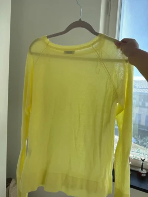 Tunn gul stickad tröja - Säljer en tunn och lätt gul stickad tröja med rund halsringning och långa ärmar. Materialet känns mjukt och luftigt.