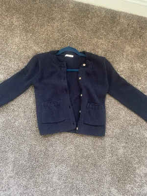 Marinblå cardigan  - Denna kofta är väldigt fin med sina detaljer och fickor på sidorna, 