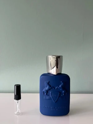 1 ml sample av Parfums de Marly Percival  - Ett sample på 1 ml av Parfums de Marly Percival. Det är en fräsch, tvålig sommardoft från parfums de marly. Den passar bra till sommaren men funkar även lika bra året runt. Våra samples är helt nya och är gjorda av glas. Det är fritt fram att skriva till oss om ni har frågor.