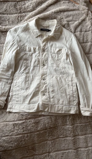 Vit overshirt från J.Lindeberg XS - Snygg vit overshirt från J.Lindeberg i storlek XS sitter som S . Klassisk modell med två bröstfickor och två sidofickor, knäppning framtill och krage. Perfekt att slänga över en hoodie eller t-shirt för en clean och stilren look.