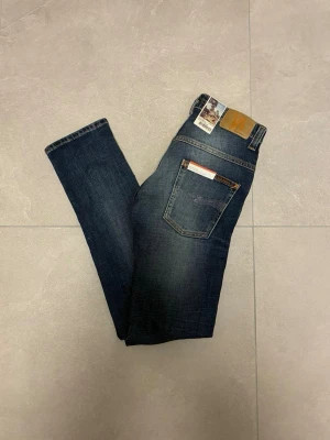 Nudie jeans - Tjena! Säljer nu ett par riktigt feta nudie jeans med en riktigt snygg tvätt. De är HELT NYA, med lapparna fortfarande kvar. Jeansen är i modellen ”Thin Finn”, vilket är en slim fit passform. De är ju som sagt helt nya, så finns inga defekter. De är i storleken ”28/32”. Hör av er vid närmsta fundering!🙌