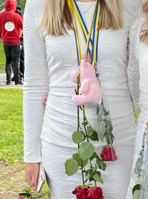 Klänning  - Vit kort klänning. Klänningen har en figurnära passform och är perfekt för student eller sommarens tillfällen. Materialet känns mjukt och har en elegant struktur.