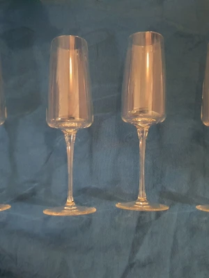 Champagne- & vattenglas - Säljer eleganta champagneglas i transparent glas med klassisk smal form och lång fot. Perfekta för att fira speciella tillfällen med bubbel. Stilrena och passar till alla typer av dukningar. Samt vattenglas. 4 av varje.