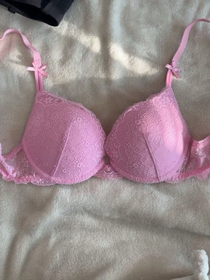 Rosa spets bh - En rosa push-up bh med spets i storlek 70A från Lindex. Använd ett fåtal gånger. Är i väldigt fint skick.